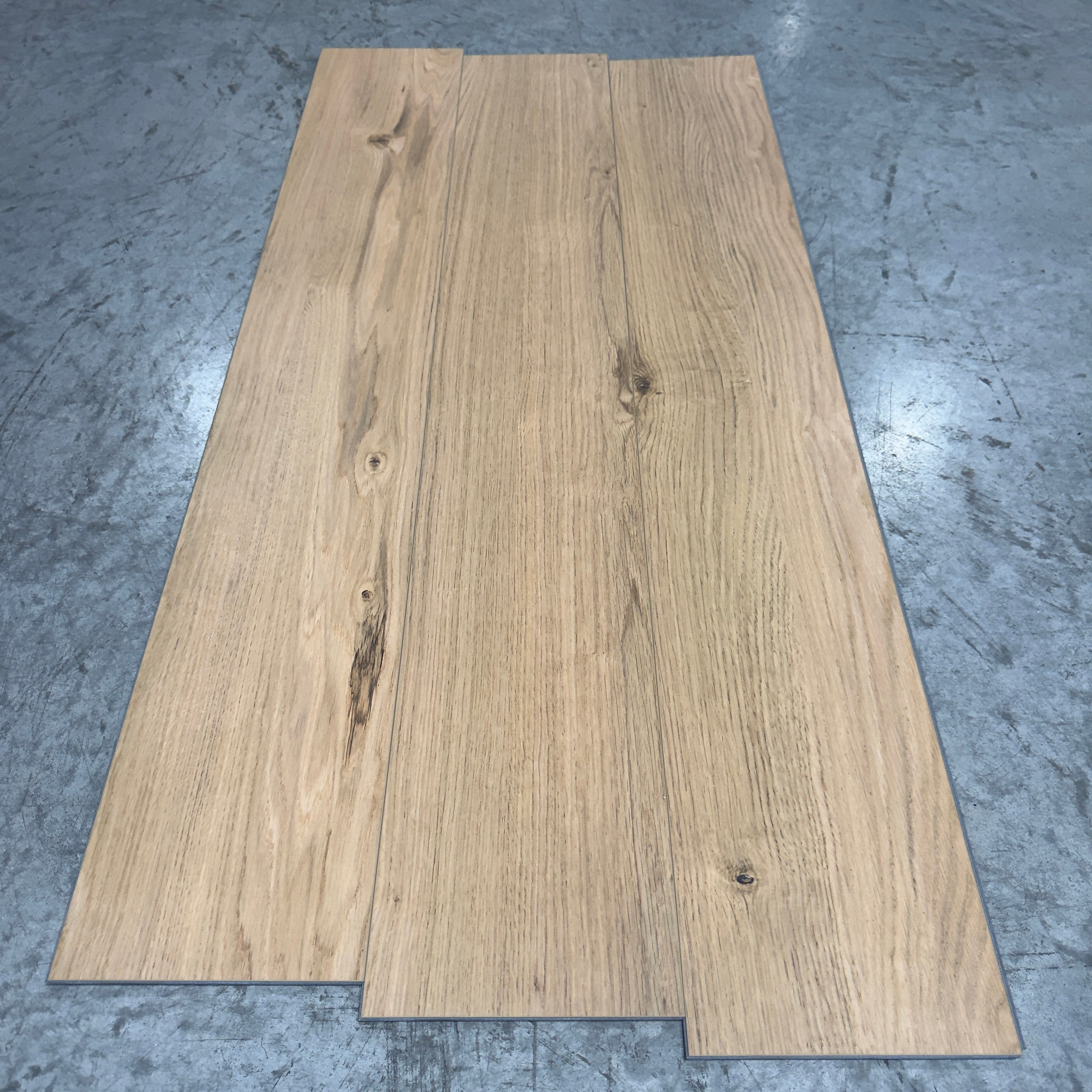 Mohawk LVP Flooring 567 - 5MM - Three planks fanned showing medium warm-tan oak grain with flowing lines and knots